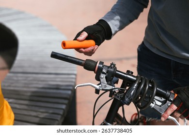 Hands of a bicycle mechanic installing new handlebar grips, replacing worn-out ones. Bike repair, diagnostics, and adjustment of cycling components. Manual maintenance of eco transport - Powered by Shutterstock - Get 15% off with code: PIKWIZARD15