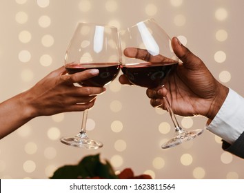 Hands Of Black Man And Woman Toasting With Red Wine, Restaurant Background, Cropped