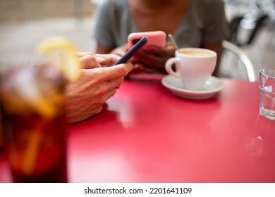 Hands Of Black Woman And Caucasian Man Text Messaging Using Mobile Phone At Outdoor Cafe