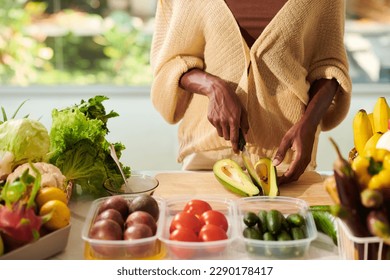 Hands of Black woman cutting fresh avocado when making breakfast - Powered by Shutterstock