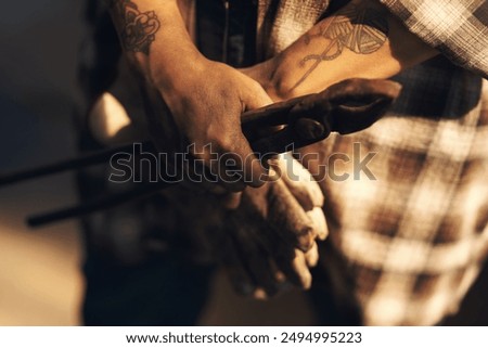 Hands, blacksmith or tool in workshop for protection, forging or safety. Person, equipment or preparation in metal industry for labor, project or artisanal creativity in foundry for small business