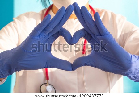 Hands in blue doctor gloves making heart . Medical assistance concept