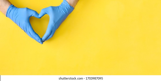 Hands In Blue Medical Gloves Showing Shape Of Heart On Yellow Background