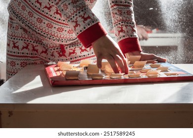 hands boy opening Christmas advent calendar on a dining table. preparation at home - Powered by Shutterstock