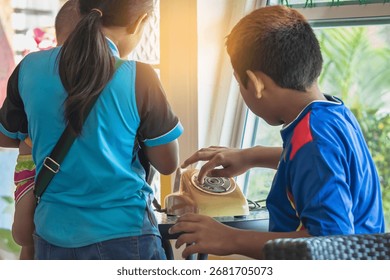 Hands of boy try to using old phone or dial telephone. Boy curious and tried using old rotary phone or dial phone. Curious child play with antique vintage rotary old landline phone. Old fashioned.