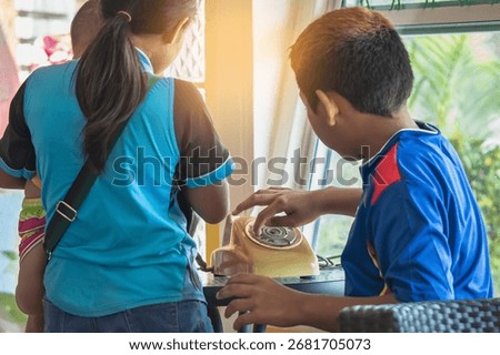 Hands of boy try to using old phone or dial telephone. Boy curious and tried using old rotary phone or dial phone. Curious child play with antique vintage rotary old landline phone. Old fashioned.