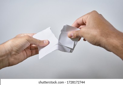 Hands Breaking A Sheet Of Paper On White Background