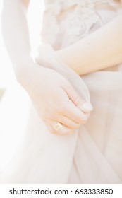 Hands of the bride on a wedding dress on a sunny day. fine art photography.