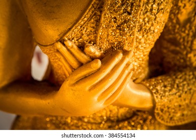 hands of buddha statue touching the heart on chest level.