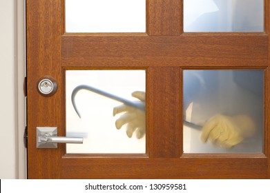 Hands Of Burglar, Thief  With Gloves, Holding Crowbar Trying To Break In Home, Unlock Door, Blurred Visible Silhouette Behind Milky Windows, With Copy Space.