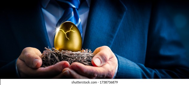 Hands Of Business Man Holding Cracked Golden Nest Egg - Investment Maturity Concept - Powered by Shutterstock