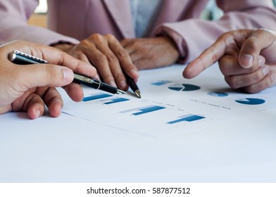 hands of business people pointing on data graph document at the office - Shutterstock ID 587877512