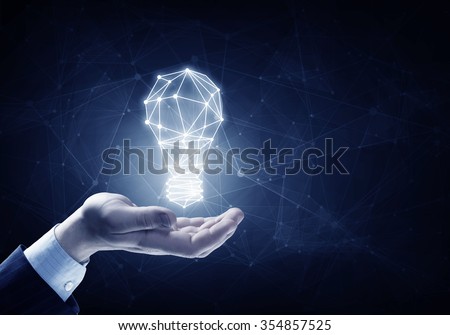 Hands of business person holding illuminated light bulb sign 