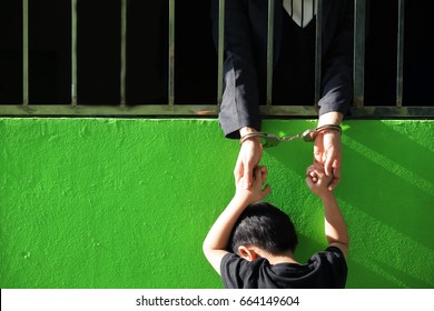 Hands Of Business Woman In Jail Holding With Her Son Outside