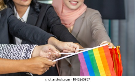 Hands Of Business Women From Different Ethnic Races And Cultures  Express Support To LGBT With Flags In An Office