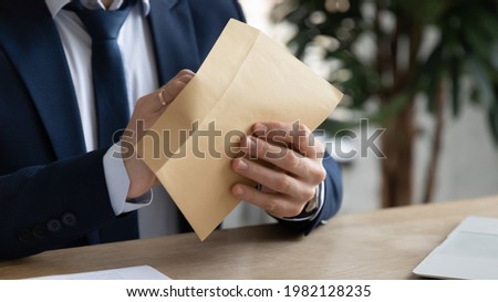 Hands of businessman opening paper envelope, taking out letter, receiving mail, notice from bank, unpacking financial document, bill, bribe. Correspondence, paperwork, invitation concept. Close up