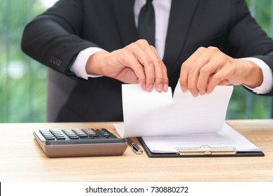 Hands Of Businessman Ripping Loan Agreement At The Desk, Break The Rules - Failure Business Concept