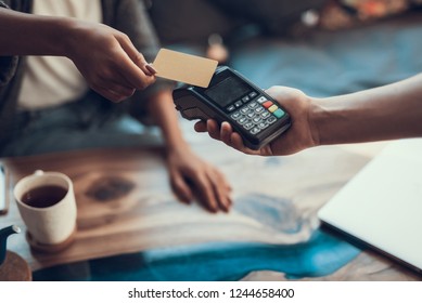 Hands of cafe visitor holding credit card and putting it to the card payment machine - Shutterstock ID 1244658400