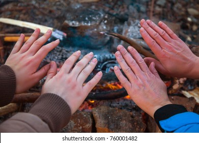 hands at campfire