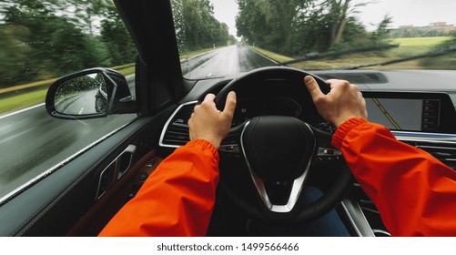 Hands Of Car Driver On Steering Wheel, Driving Car At A Rainy Day On A Country Road,  Road Trip - POV, First Person View Shot