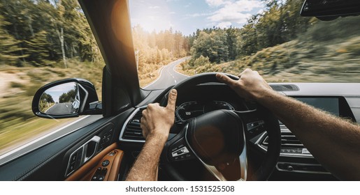 hands of car driver on steering wheel, Driving car at autumn day on a country road, having fun driving the empty highway on tour journey - POV, first person view shot