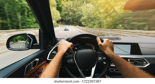 Hands Of Car Driver On Steering Wheel, Fast Driving Car At Spring Day On A Country Road, Having Fun Driving The Empty Highway On Tour Journey - POV First Person View Shot