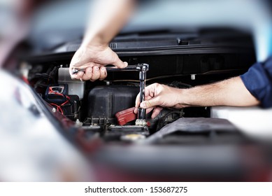 Hands of car mechanic in auto repair service.