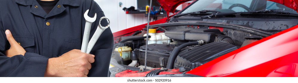 Hands Of Car Mechanic With Wrench In Garage.