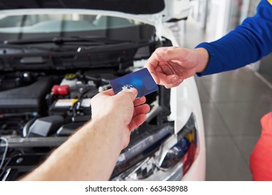 Hands Of Car Mechanic With Wrench In Garage, Payment By Credit Card.