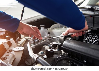 Hands Of Car Mechanic With Wrench In Garage