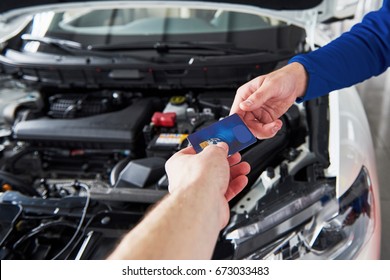 Hands Of Car Mechanic With Wrench In Garage, Payment By Credit Card.