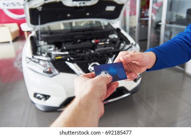 Hands Of Car Mechanic With Wrench In Garage, Payment By Credit Card.