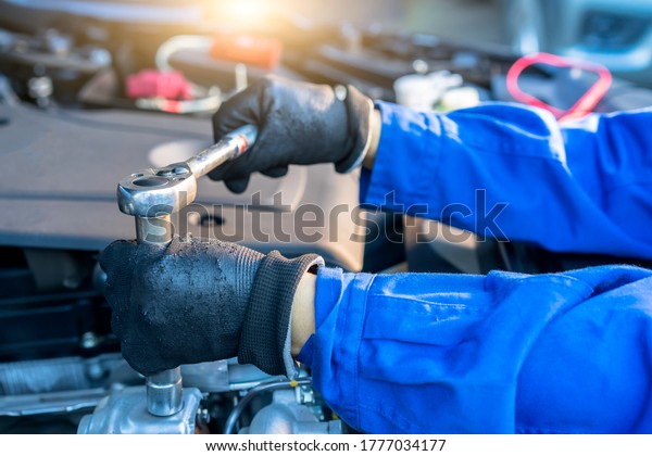 Hands of car mechanic with\
wrench  in garage for transport automobile, Car Service, Car\
Maintenance