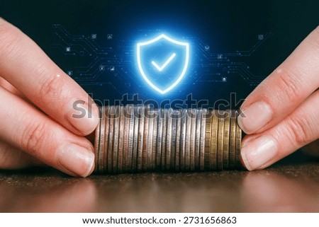 Hands are carefully placing coins in a stack, symbolizing wealth management. A digital shield graphic represents security in financial transactions, reflecting modern financial practices.