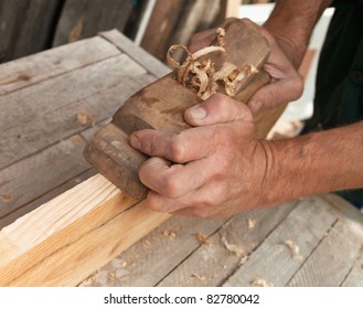 Hands of a carpenter planed wood, workplace - Shutterstock ID 82780042