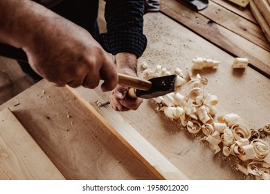 Hands of a carpenter working with chisel and hammer
