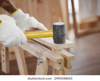 Hands of carpenters working timber woodworking in carpentry workshops, craftsmen are using rubber hammers to adjust timber frames for wooden Furniture in workshops. - Powered by Shutterstock