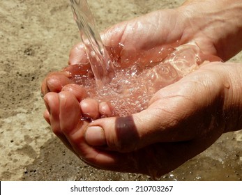 hands catching the stream of water