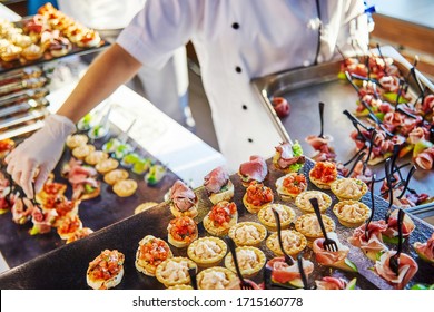 Hands of a cater in white gloves laying out sandwiches - Shutterstock ID 1715160778