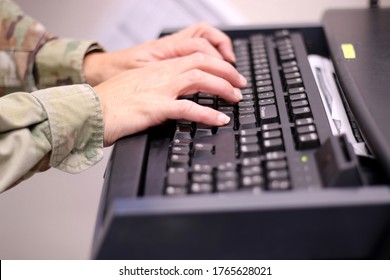 Hands Of A Caucasian Female Military Health Care Provider In Uniform Typing Notes In A Medical Clinic During The Covid-19 Pandemic.