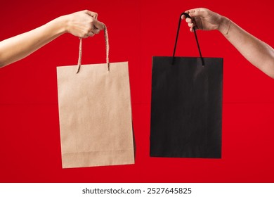 Hands of caucasian women holding black and brown gift bags with copy space on red background. Black friday, cyber monday, shopping, cyber shopping, sales, retail and shipping concept. - Powered by Shutterstock