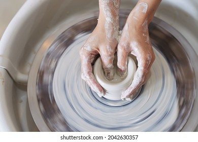 Hands Of Ceramist Modelling Vase On Potters Wheel, View From The Top