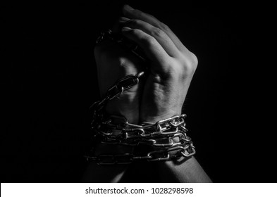 Hands are chained in chains isolated on black background