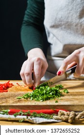 Hands chef cut herbs. Black background, side view, kitchen, space for text - Shutterstock ID 1372655252