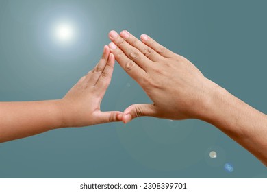 Hands of a child and adult merging on isolated flare background. - Shutterstock ID 2308399701