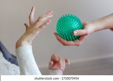 hands of a child with cerebral palsy exercises with a ball development of tactile sensations