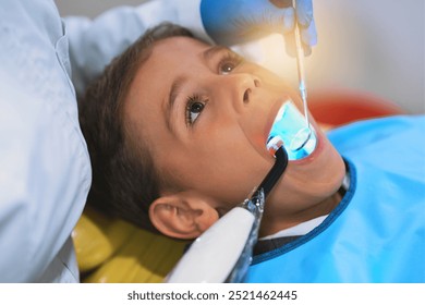 Hands, child and dental curing light for cleaning teeth, health and oral hygiene at pediatric clinic. Boy, dentist and uv treatment for tooth, closeup and orthodontics tools for filling cavity or dry - Powered by Shutterstock