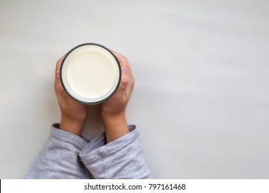 
Hands Of A Child Holding A Glass Of Milk