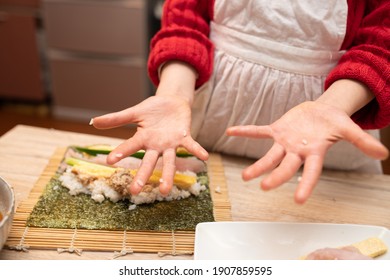 Hands Of A Child Making Sushi Rolls