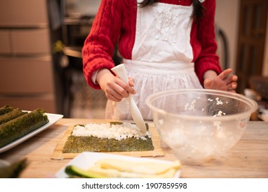 Hands Of A Child Making Sushi Rolls